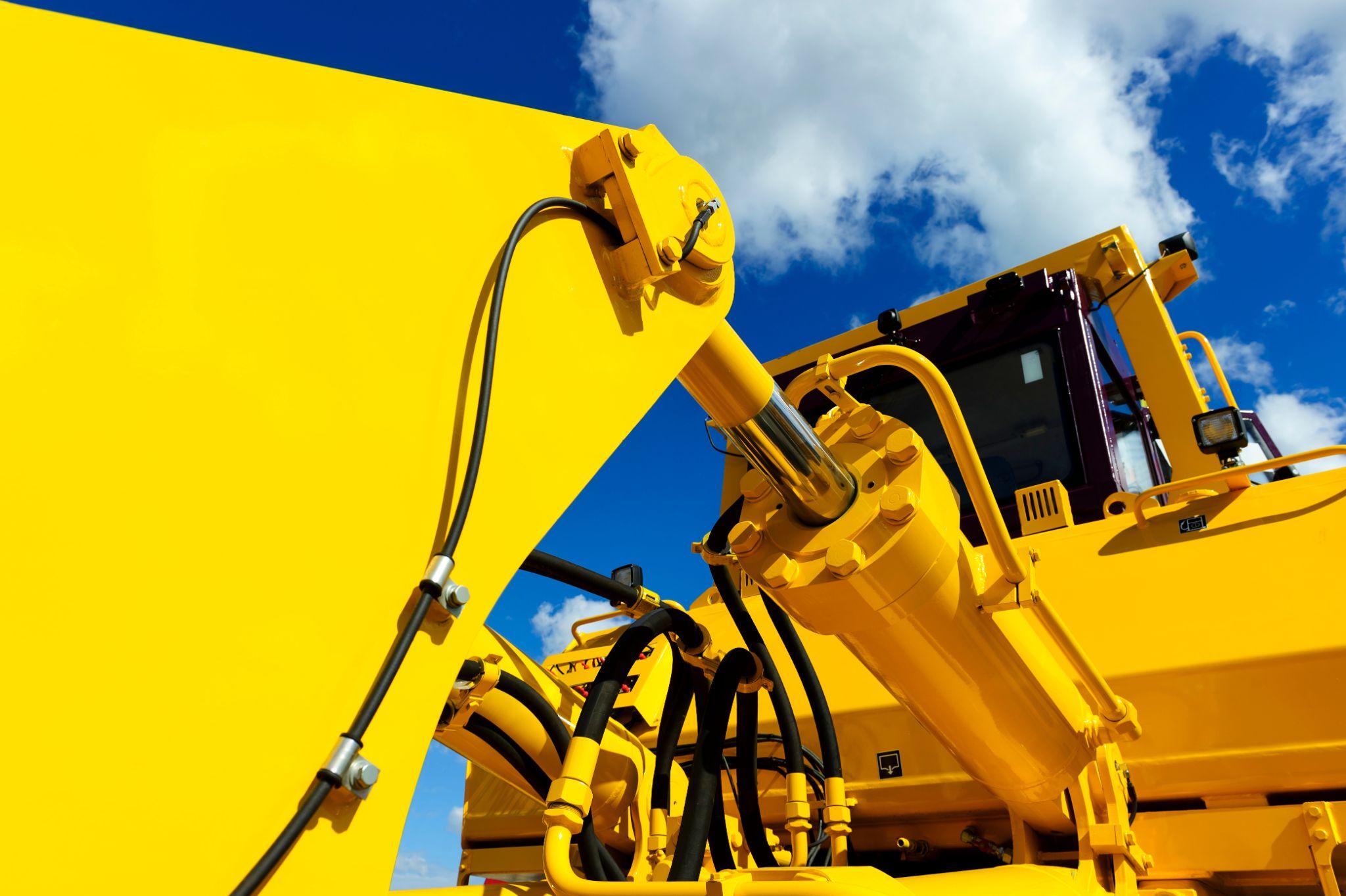 Close-up of yellow construction equipment showcasing powerful hydraulic system components.