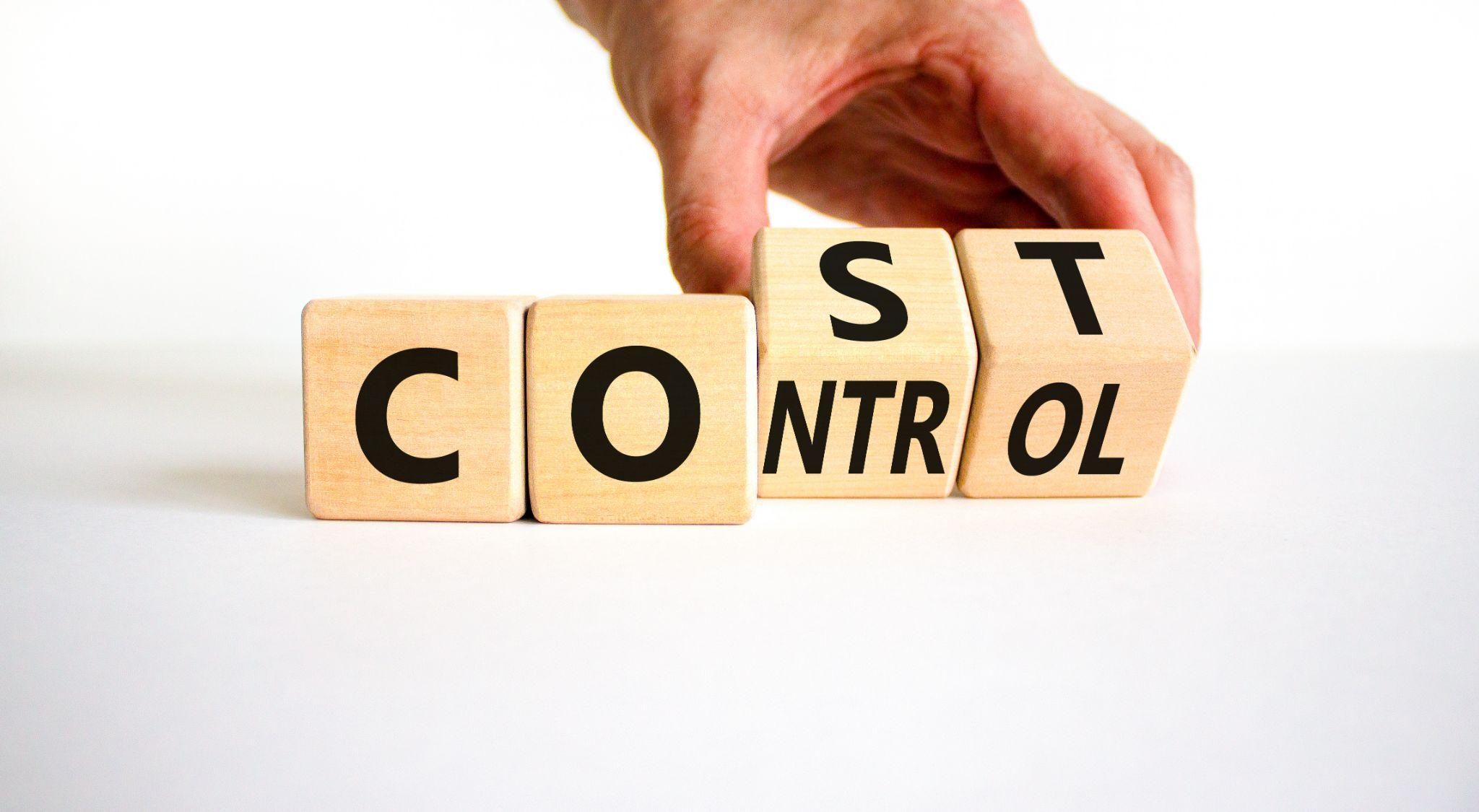 Businessman turns wooden cubes and changes the concept word Cost to Control.