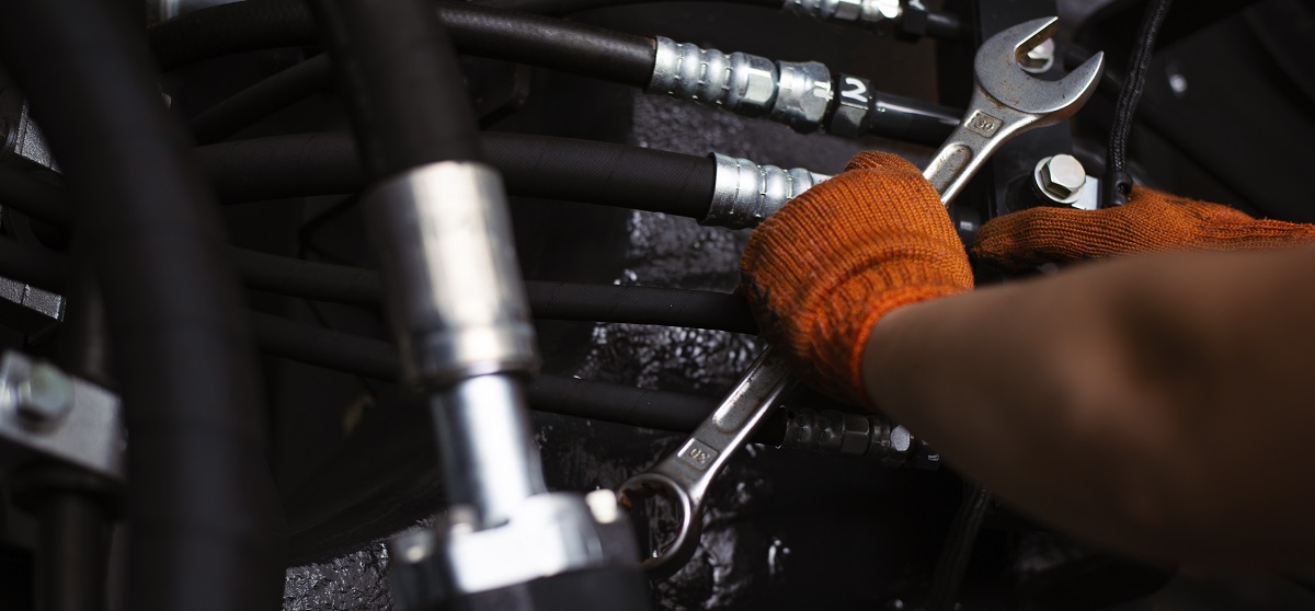 Low key photo of hydraulic pipes maintenance on heavy industry machine